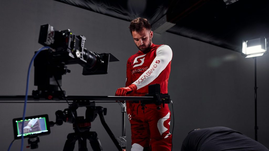 a man in a red and white suit standing in front of a camera